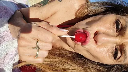 Melissa Johnson sahilde kirazlı lolipop emiyor ve yalıyor