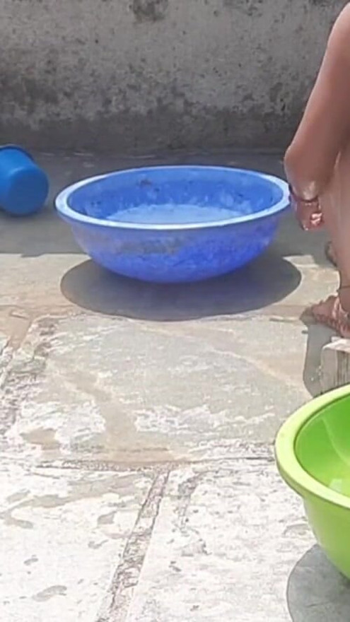 In the country's bathroom of the village, the elder sister-in-law's stepsister is soaking her saree in water and bathing naked in the open. | Clip 2