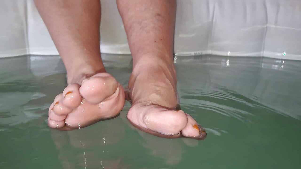 Ella se burla de mí con sus pies descalzos mientras salpica en el jacuzzi