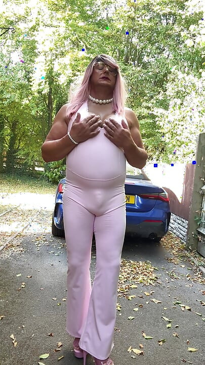 Crossdresser kellycd2022 u ružičastom kombinezonu i štiklama