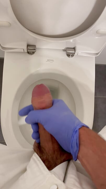 Doctor is jerking off with latex gloves at a toilet in Hospital