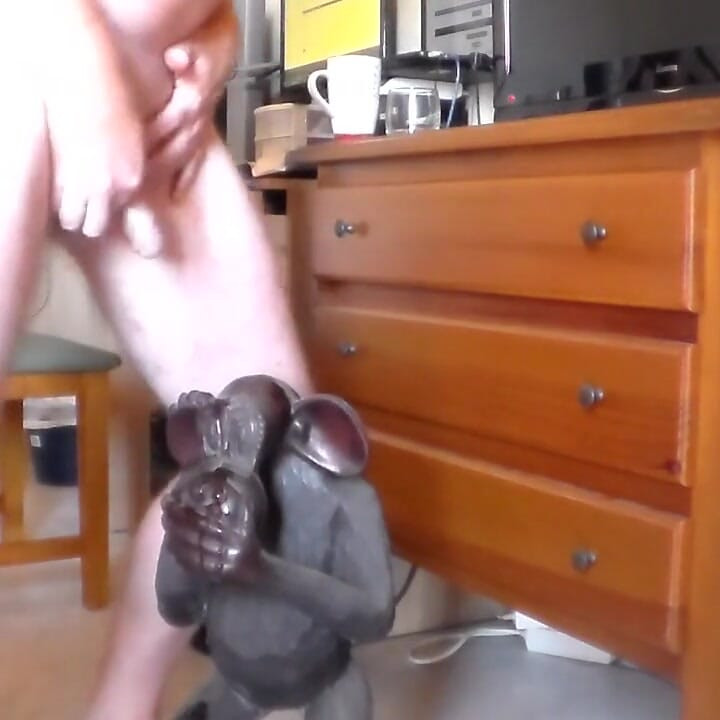 John is peeing on an ape statue