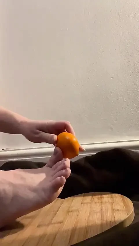 Bare feet crushing and orange