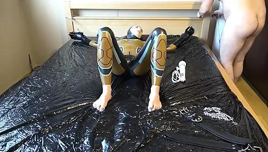 Latex Danielle is attached to the bed and masturbated with the massage vibrator