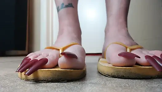 Zehennägel hängen an gelben flip-flops
