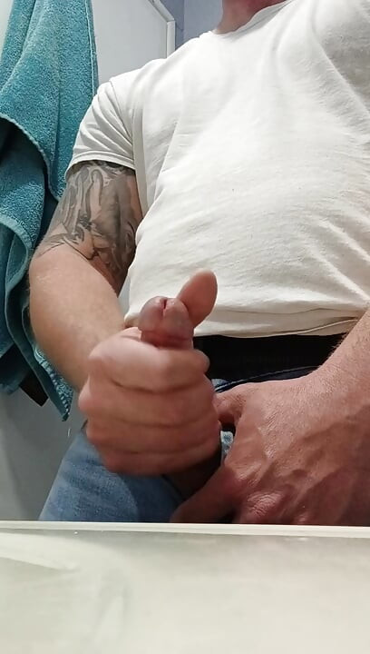 Pria kulit putih menggunakan dua tangan untuk ngocok kontol yang mengarah ke letusan mani muncrat