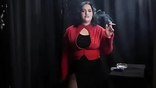 Kurvige brünette raucht in roter strickjacke