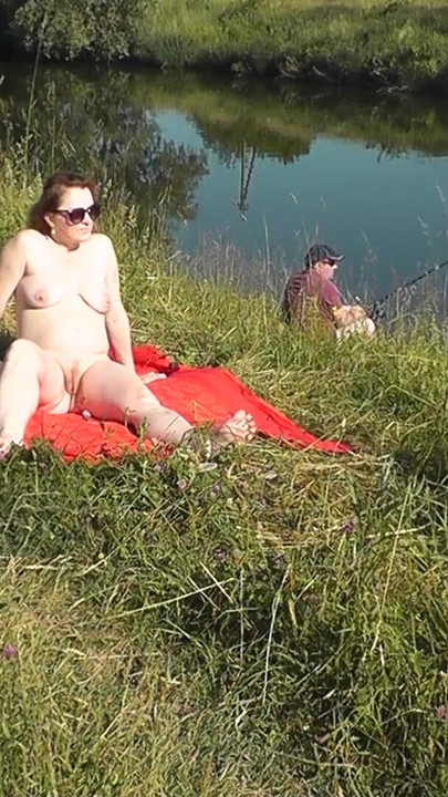 Iconic moment from "Wild beach. Sexy MILF Platinum naked sunbathing on river bank, random fisherman guy watches. Naked in"