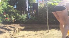 Hangend wassen in g -string en naakt in de tuin