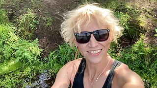 变性女孩Alexa Cosmic穿着黑色短裤和蓝色上衣在湖里游泳和玩耍
