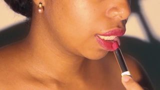 Negrita de labios sexy jugando con su lápiz labial rojo en primer plano