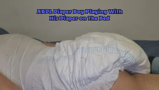 ABDL Diaper Boy jouant avec sa couche sur le lit