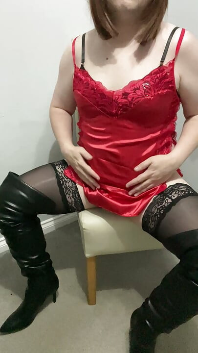 Crossdresser u crvenom satenskom PVC grudnjaku i gaćicama, drka i šamara se