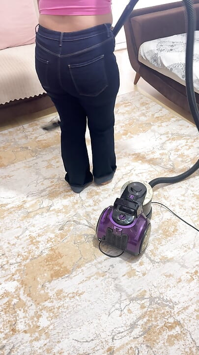 Vrouw met ronde vormen die het huis schoonmaakt in een broek