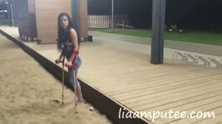 Mujer amputada con muletas en la playa