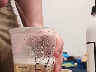 Filhote de urso quase enchendo um copo do Starbucks com mijo