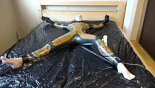 Latex Danielle wird am Bett befestigt und mit der massage mit dem vibrator masturbiert