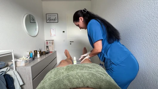 Heiße masseuse zieht latexhandschuhe für einen schmutzigen happy end-cumshot an