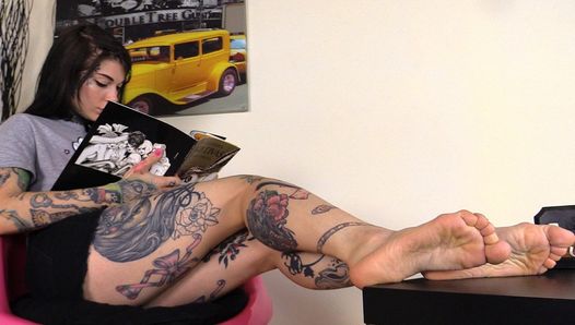 Chica tatuada descalza flexiona los dedos de los pies