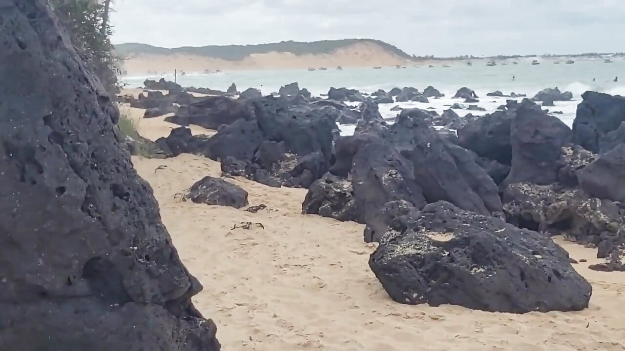 Piękna brazylijska robienie na plaży z ludźmi przechodzącymi obok