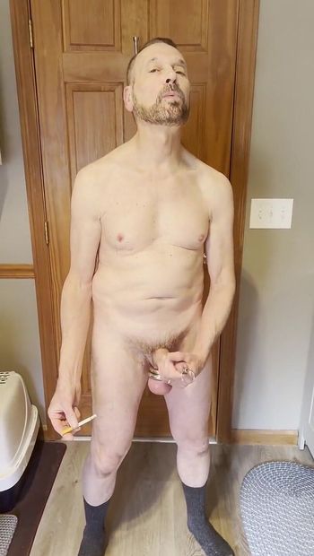 Smoking with Ball Stretcher on Big Balls and Penis Plug on a Big Cock