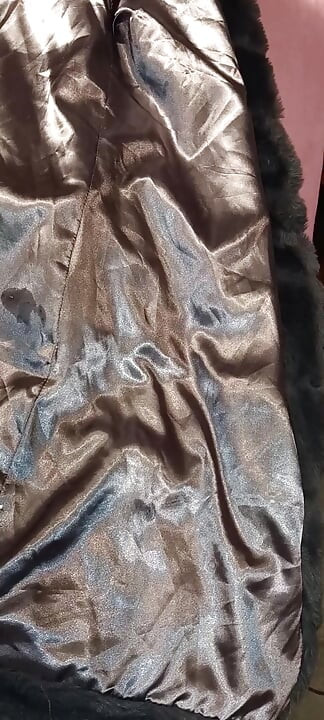 Il baise la doublure brillante d’un faux manteau de fourrure