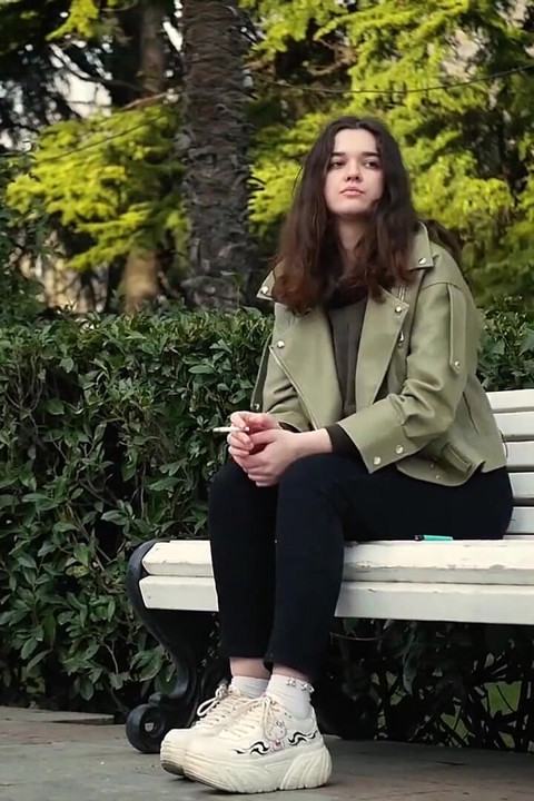 Young Brunette Is Taking an Unhurried Stroll with Allwhite 120mm Cigarette