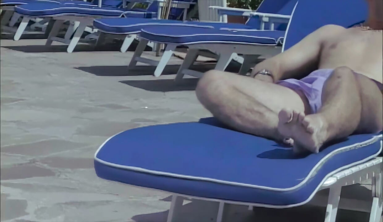 Levando rola na espreguiçadeira da beira da piscina