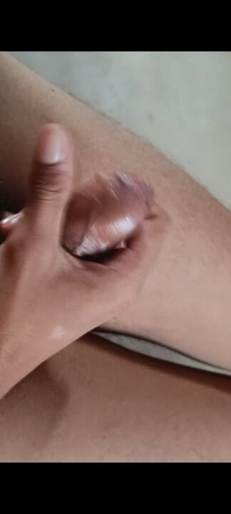 The boy is shaking his penis in his hand and ejaculating.