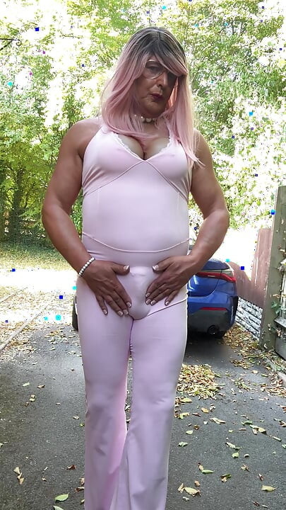 Crossdresser kellycd2022 u ružičastom kombinezonu i štiklama