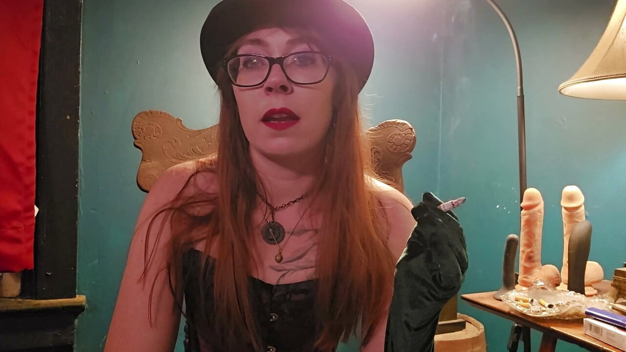Röker iklädd en lila korsett, handskar och hatt