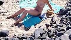 Un beau-père masse sa belle-fille nue avec un écran solaire sur la plage