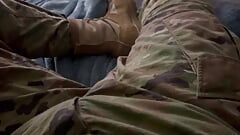Vs leger soldaat trekt zich af in uniform en pronkt met zijn laarzen