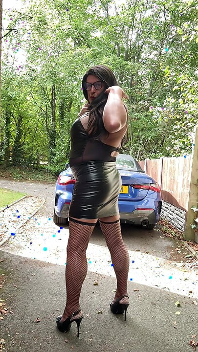 Seksi transvestit kellycd2022 u crnom PVC bodiju i mrežastim čarapama i štiklama