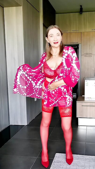 An elegant mature lady in red shocks with her huge breasts.