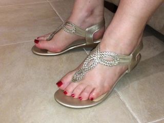 Elegantes sandálias de tanga dourada e pés sensuais