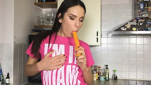 Verspielte junge burnette nataly gold bereitet karotte auf die richtige art und weise vor