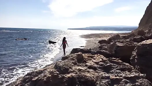 Yalnız gür Rus bebek deniz kıyısındaki kayada amını oyuncak yapıyor