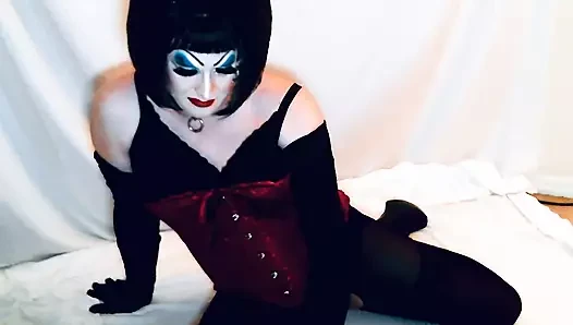 Ağır makyajlı kadın kılıklı drag queen göt tıkaçlarıyla, götten ağza oynuyor