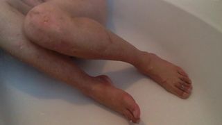 Wunderschöne männliche Füße mit Zehenringen in der Dusche