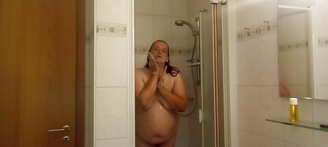 Real woman showering soft belly, wet skin