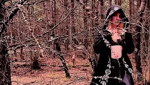 Bruja traviesa está jugando con un vibrador en el bosque
