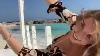 Ragazza calda danza sul bordo della spiaggia