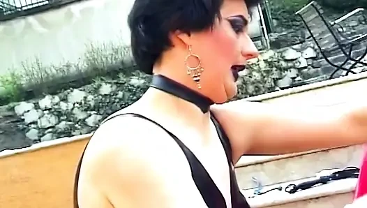 Brunette dominatrix menyematkan jepitan baju di kontol
