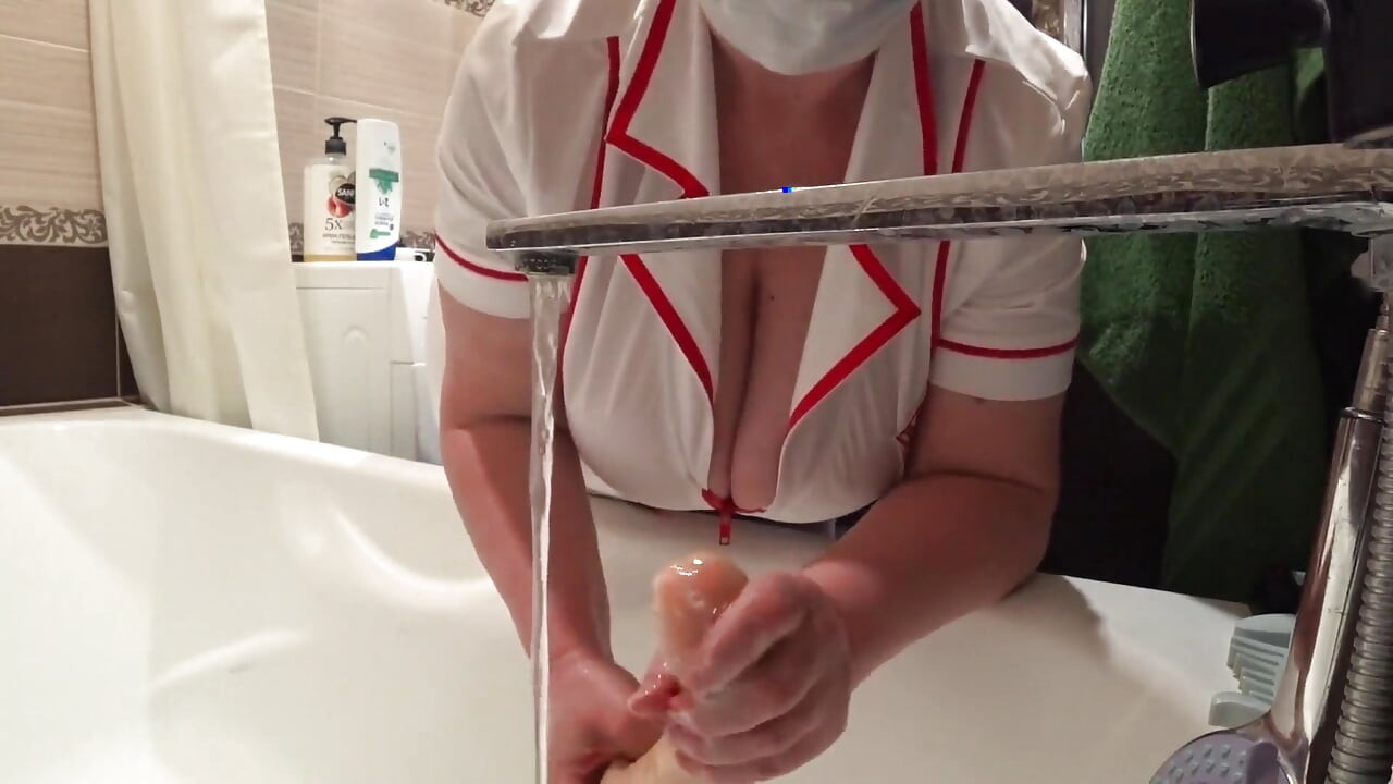 Grande. Un Escote Elegante Bajo Una Ba Médica. Enfermera Madura Con Lente De Cámara En El Trabajo.