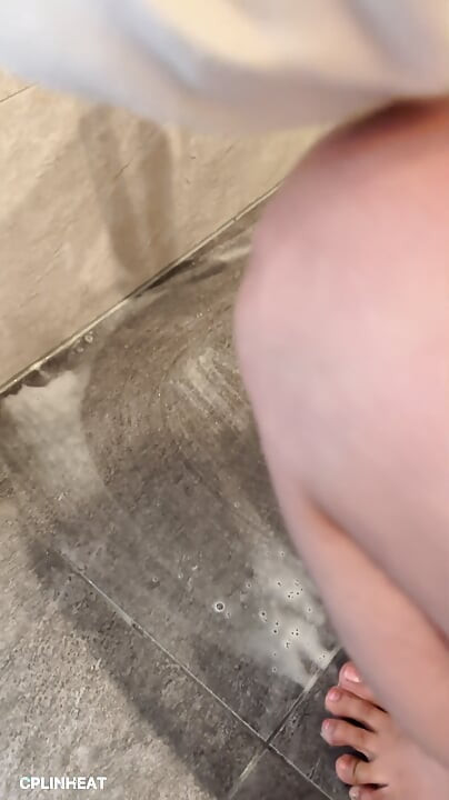 Reinigung des badezimmerbodens mit ihrem getränkten hoodie, auf den knien