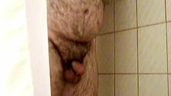 Harige mollige beer streelt zijn pik onder de douche