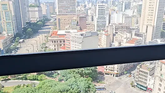 Gadis ini lagi asik di depan jendela mirante sampa sky di pusat kota são paulo sambil ditonton semua orang