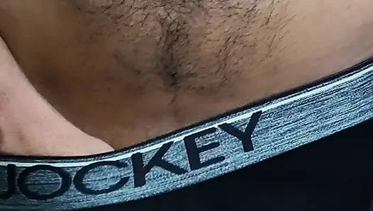 Young man wearing black underwear is dancing cock while holding his groin area.