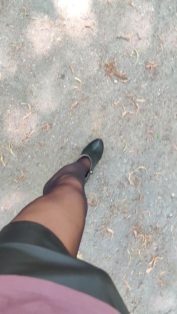 Camina con sexy botines y medias en el parque